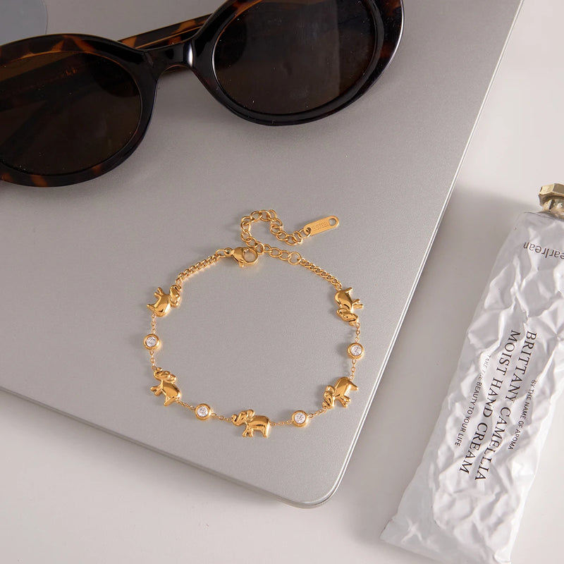 Charm bracelet on a laptop beside tortoiseshell sunglasses