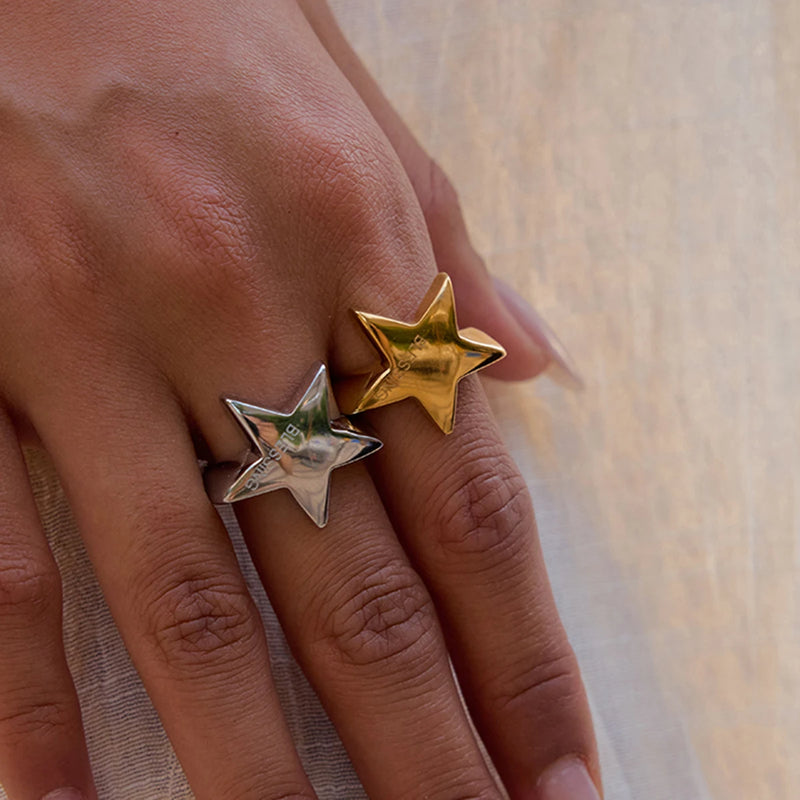 Silver-tone and gold-tone star rings worn side by side