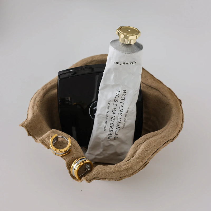 Huggie hoops on a moulded paper tray with hand cream