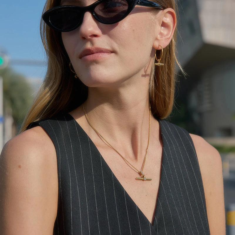 T-bar hoop earrings worn with sunglasses and a layered necklace