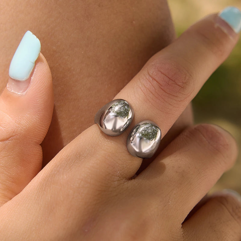 Silver-tone open ring with two rounded ends worn on a finger
