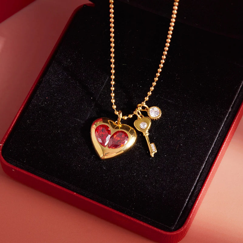 Close view of the red heart and key charms on a bead chain