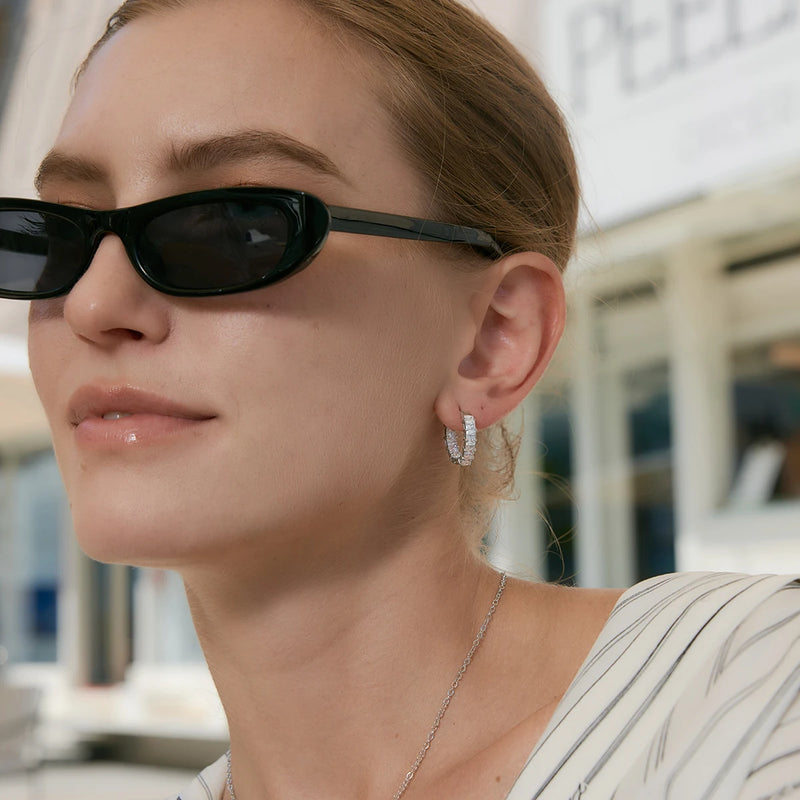 Model wearing the crystal huggie hoops with sunglasses