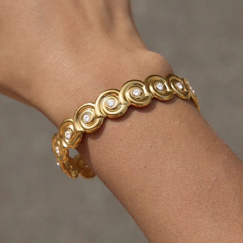 Close view of the linked spiral shell motifs on the wrist