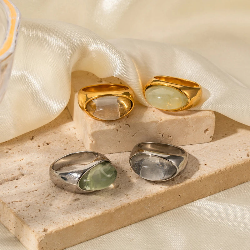 Four domed cabochon rings on stone and cream fabric
