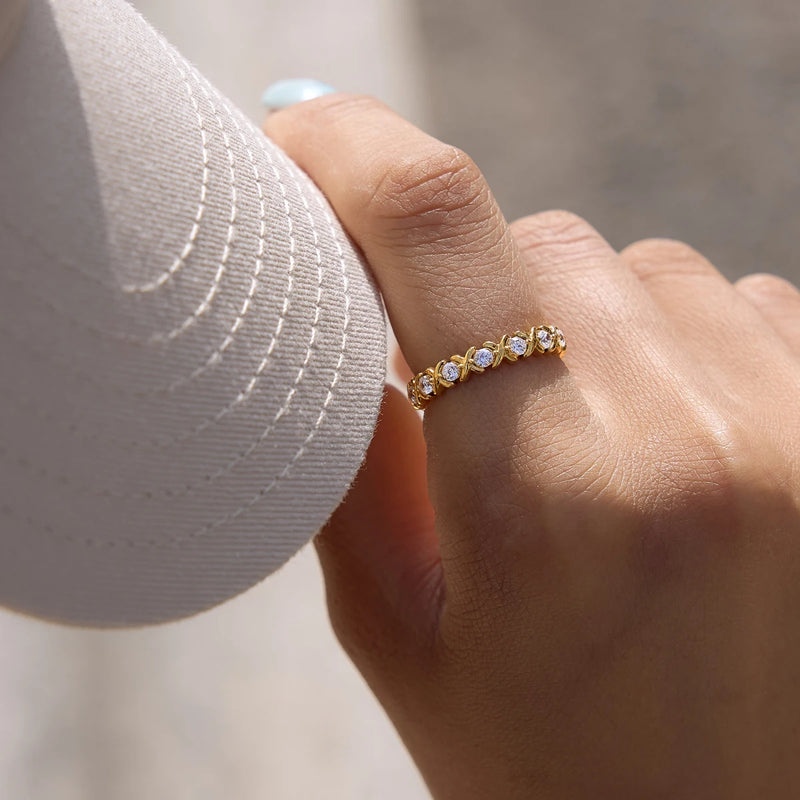 Crystal eternity band worn on a hand resting on fabric
