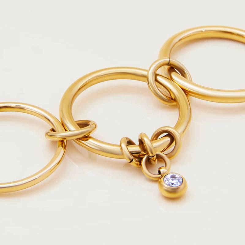 Linked bands with a crystal drop laid flat on a pale surface