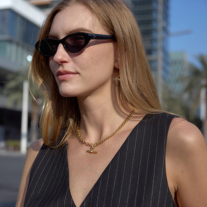 Side view of the C-hoop earring worn with a layered necklace
