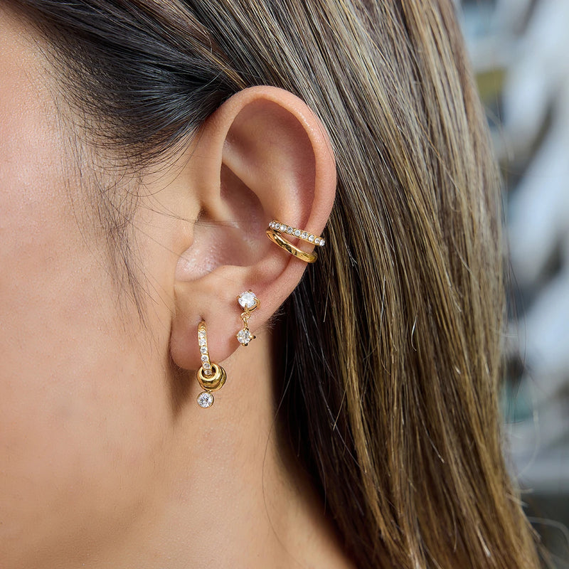 Side view of several small hoops and studs worn along the ear