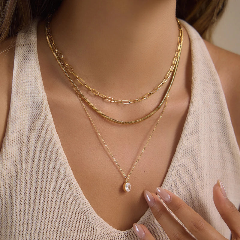 Layered chain necklace worn with a cream knit top