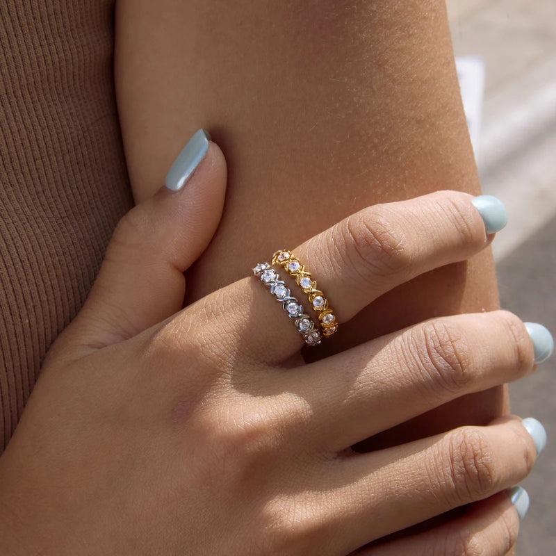 Two crystal-set eternity bands worn on a finger, arms folded