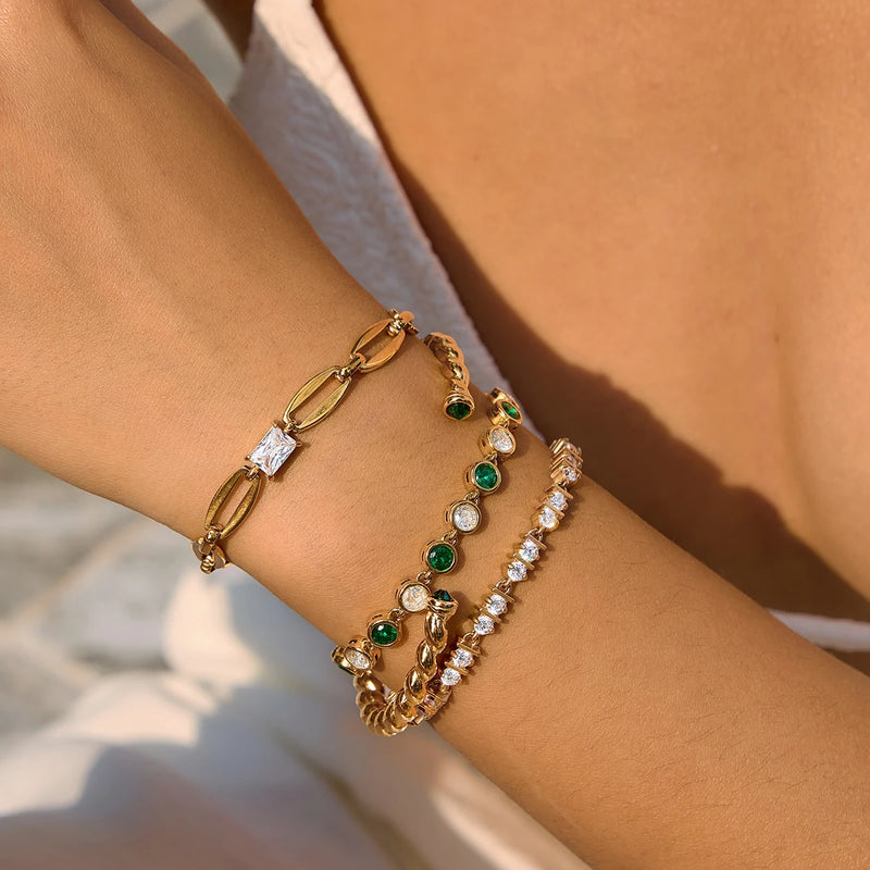 Twisted cuff worn with chain and crystal bracelets on a wrist
