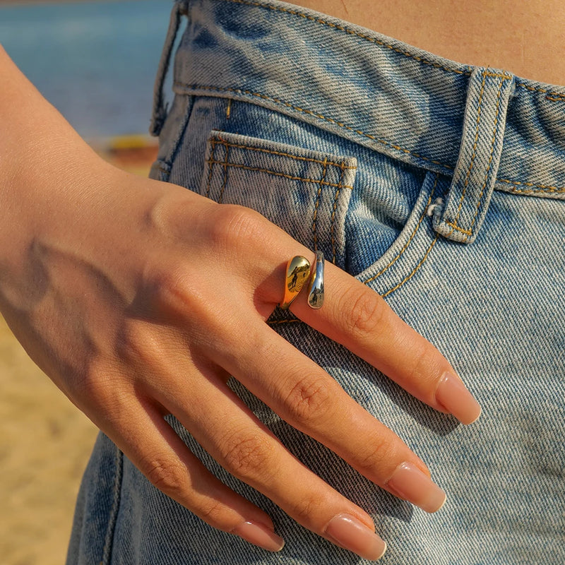 Open wrap ring worn on a hand against denim