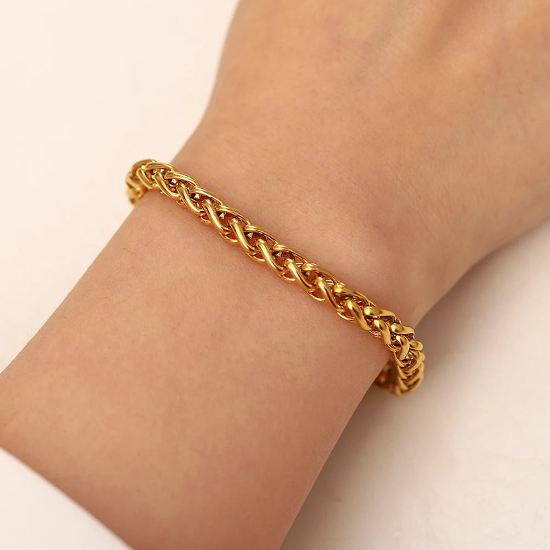 Gold-tone wheat chain bracelet worn on a wrist