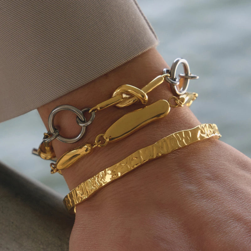 Textured pebble link bracelets worn on a wrist