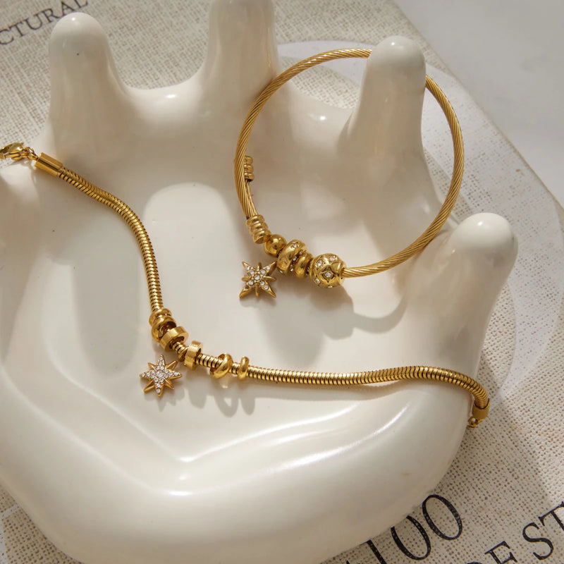 Star charm bangle draped over a white ceramic hand