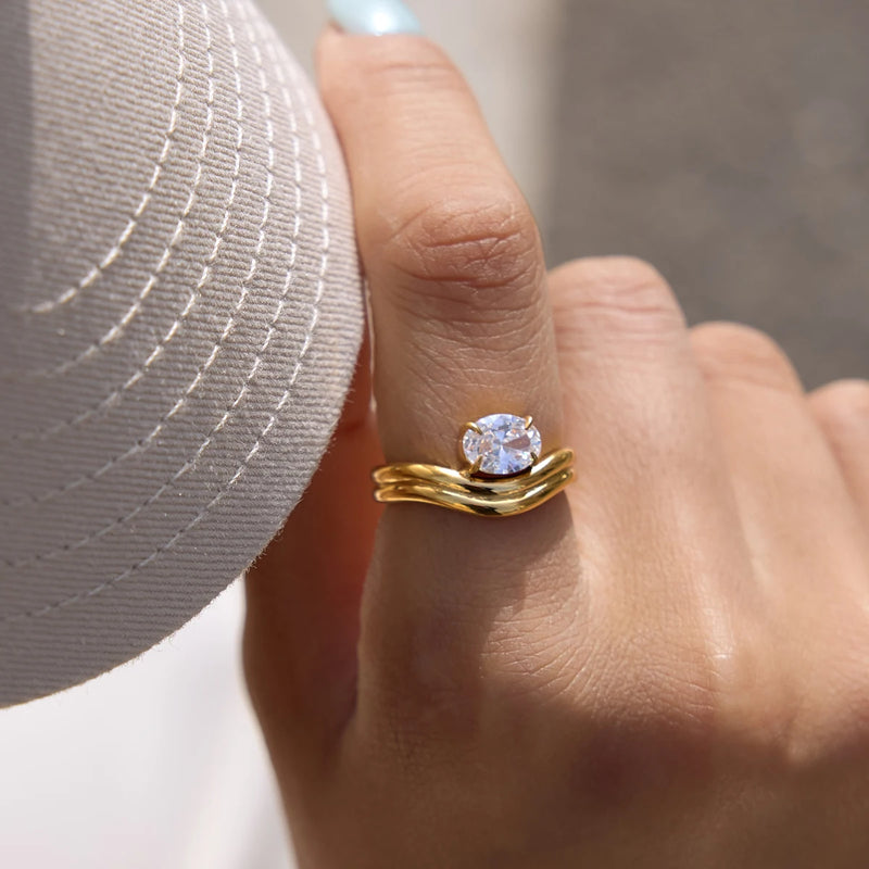 Silver-tone double wave ring with a clear stone worn on a finger
