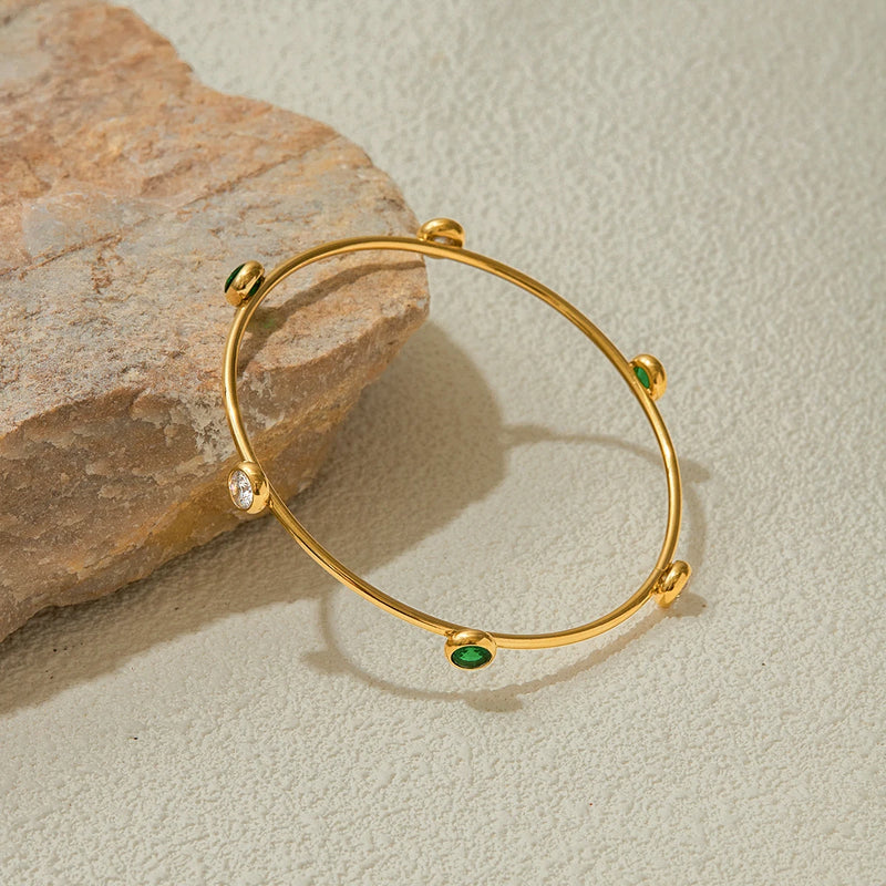 Single stone station bangle on a pale textured surface