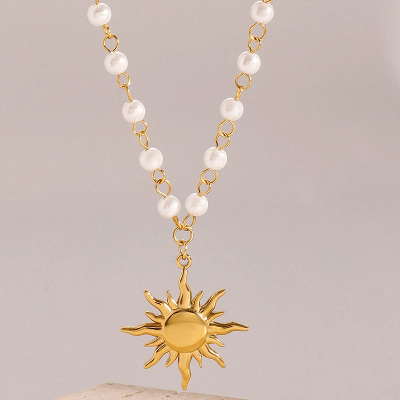 Sun pendant on a pearl chain against a pale background