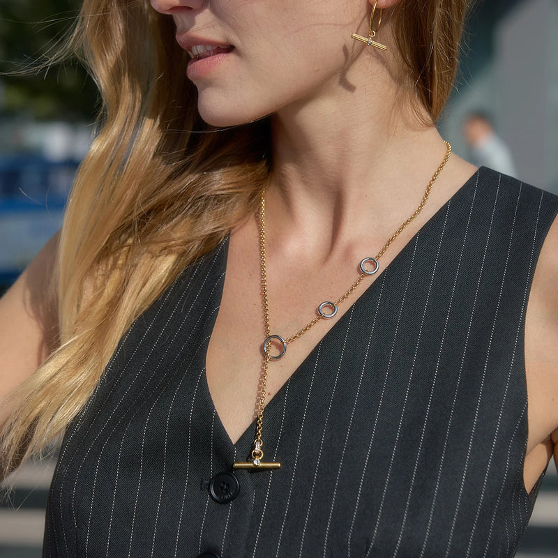 C-hoop earrings worn with a T-bar necklace and a dark top