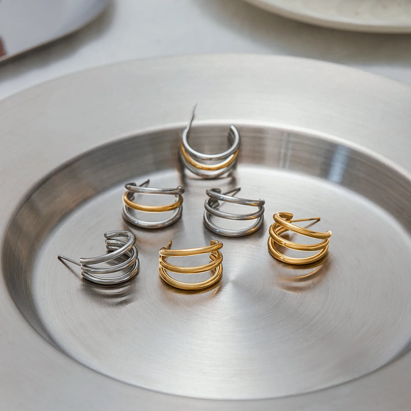 Henriette Triple-Band Hoop Earrings, all colourways arranged in a metal dish