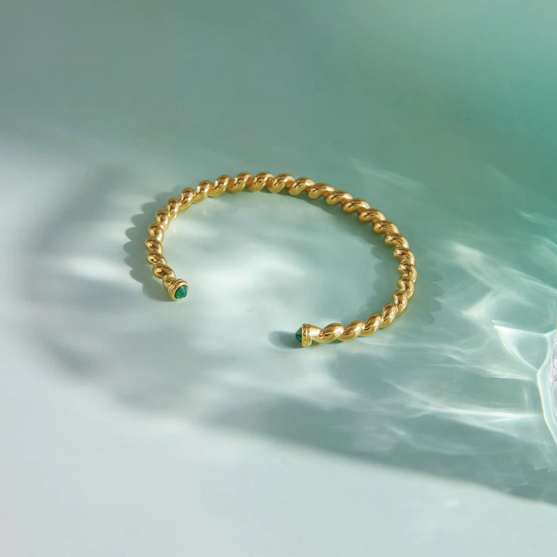 Twisted rope cuff on a pale green background with water shadows