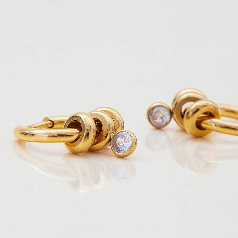 Two huggie hoops with crystal drops, close view