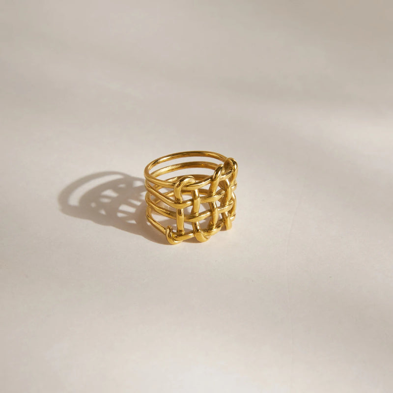 Wide basketweave ring standing upright on a pale surface