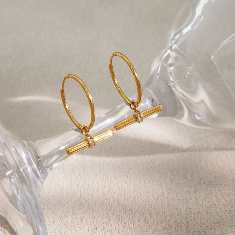 Two T-bar hoops resting against a clear glass stem