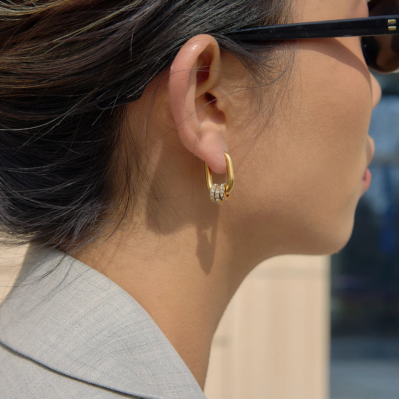 Oval hoop earring worn with sunglasses, side view