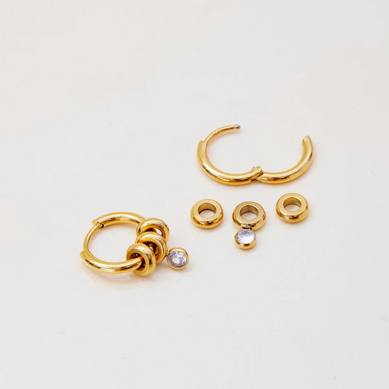 Huggie hoop shown disassembled with its separate charm parts
