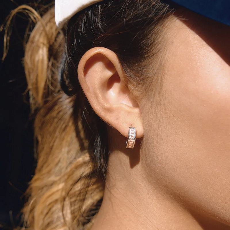 Close view of the crystal-set huggie hoop worn on the ear