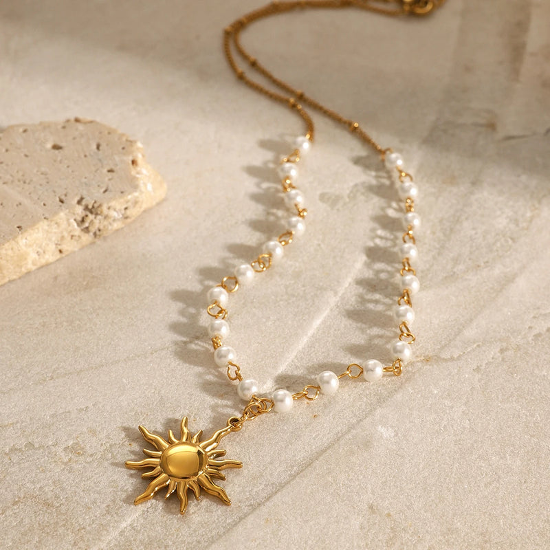 Sun pendant pearl necklace arranged on a pale stone slab