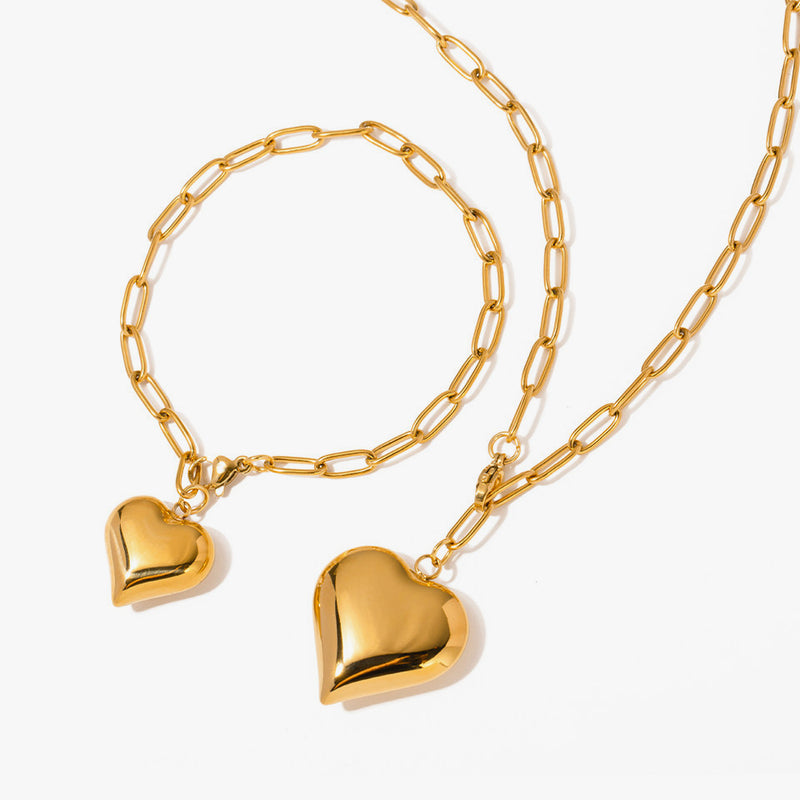 Paperclip chain bracelet and necklace each hung with a puffed heart