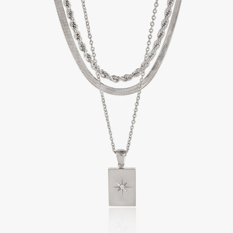 Layered silver-tone chains with a rectangular starburst pendant