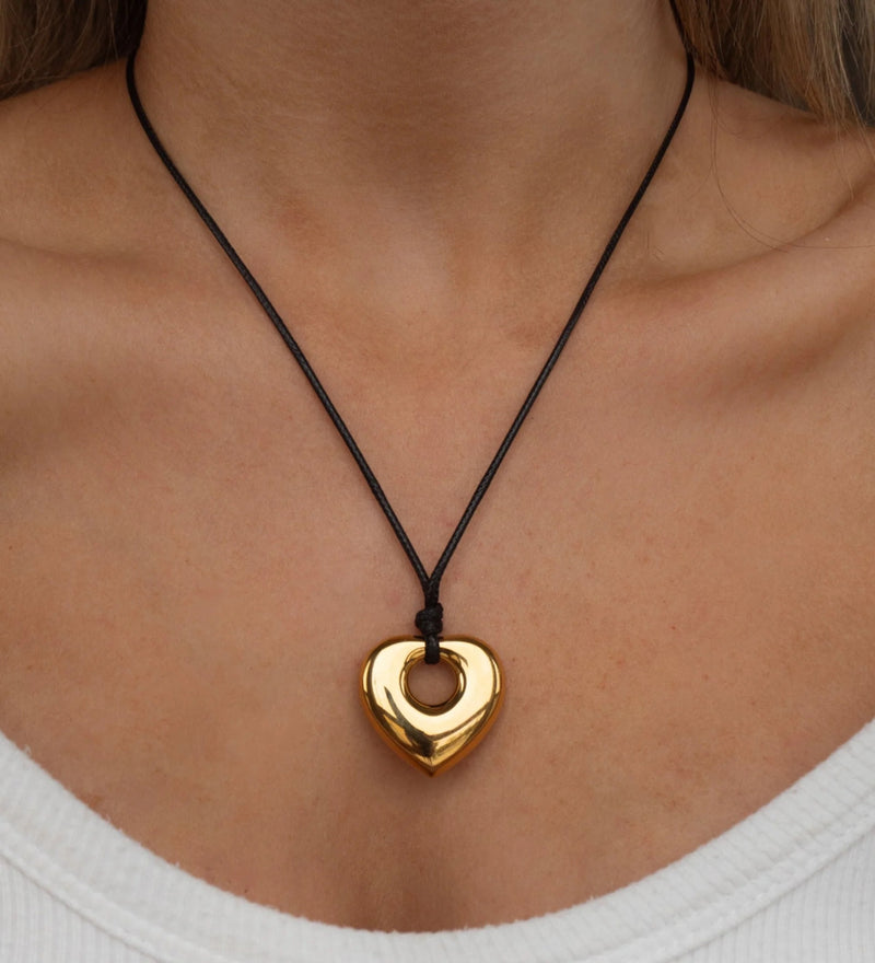 Heart cutout pendant on a cord worn at the collarbone