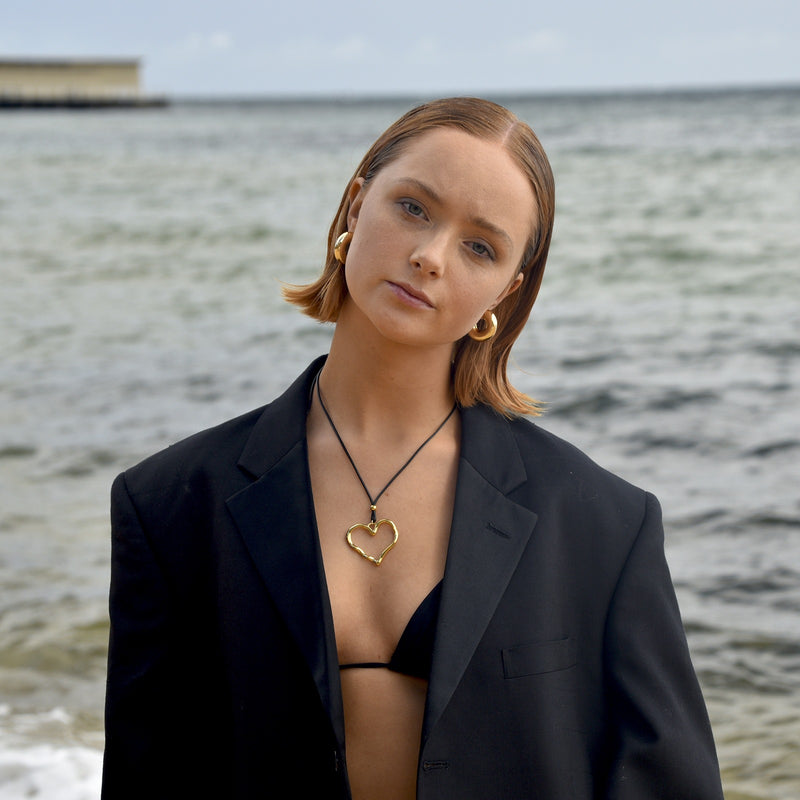 Open heart cord necklace worn with an oversized blazer
