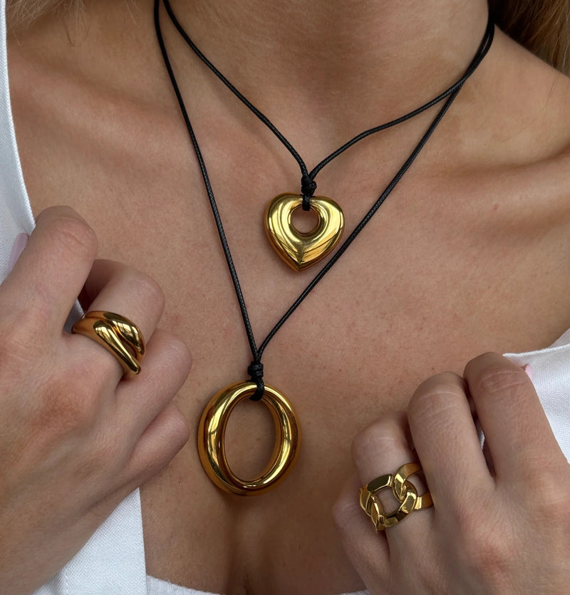 Two cord necklaces with a heart and a ring pendant, worn