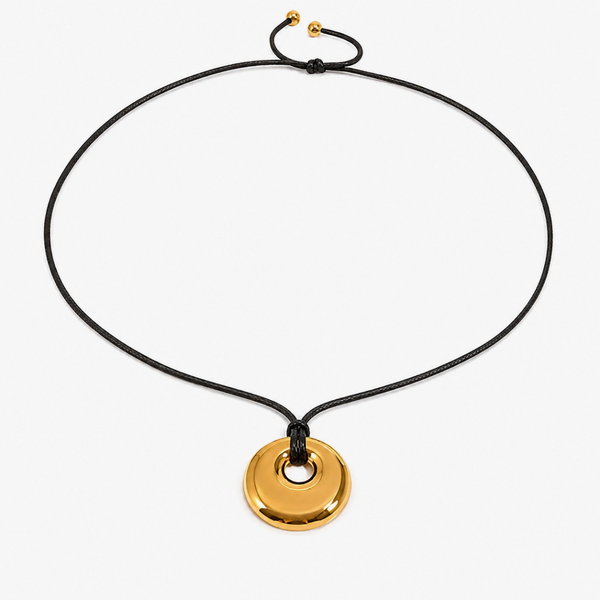 Gold-tone disc pendant with an open centre on a black cord