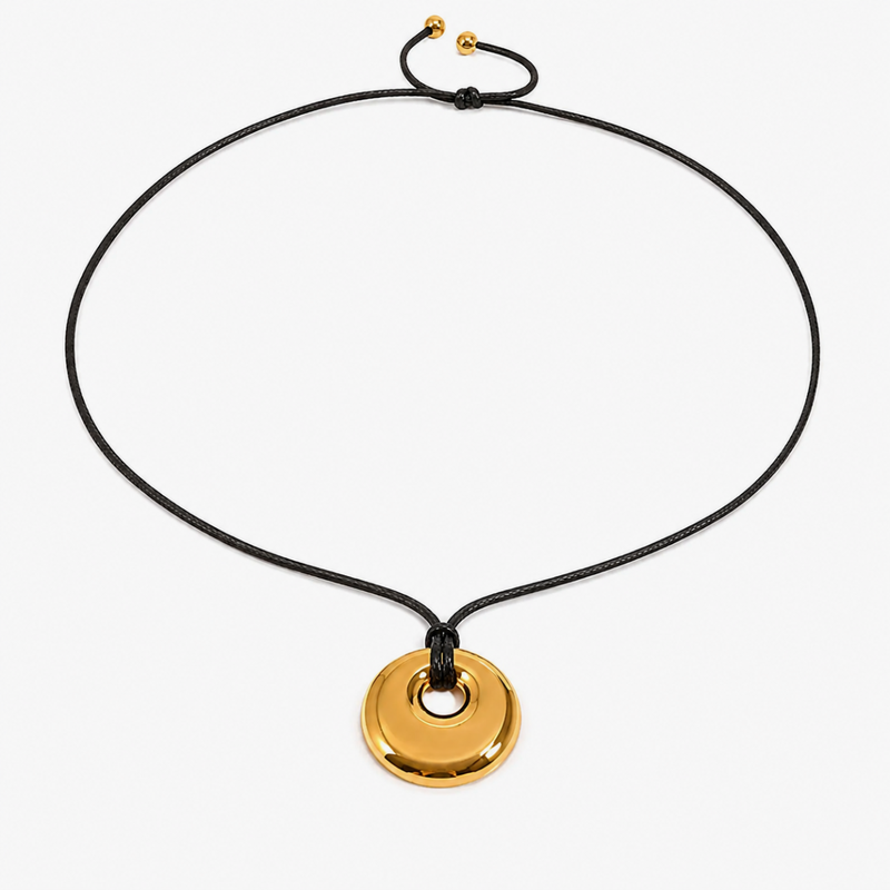 Gold-tone disc pendant with an open centre on a black cord