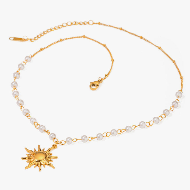 Pearl and chain necklace with a gold-tone sun pendant