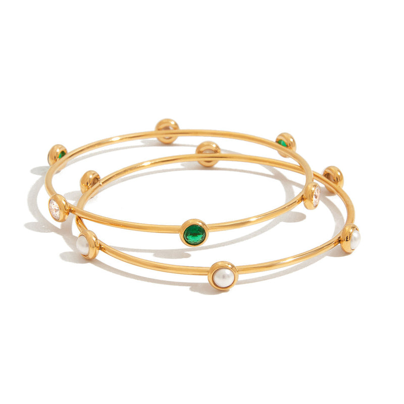 Two slim bangles set with green stones and small pearls
