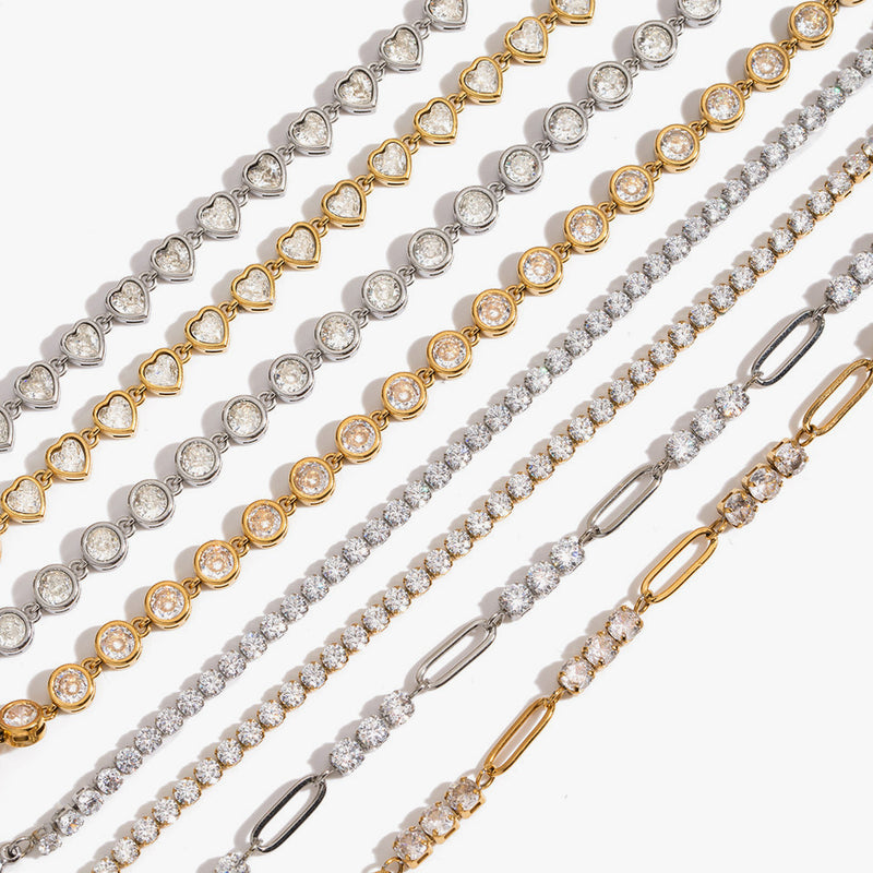 Crystal-set chain bracelets laid in a row in gold and silver tone