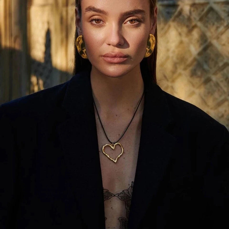 Open heart cord necklace worn with a black jacket