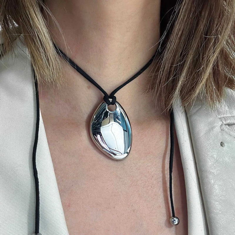 Close view of the silver-tone pebble pendant on a cord