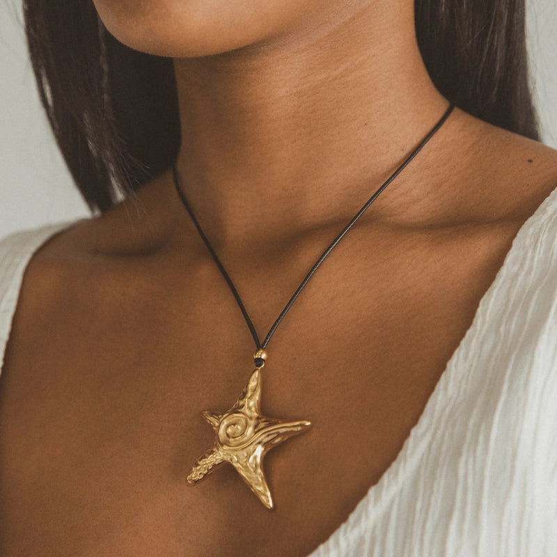 Close view of the textured starfish pendant on a black cord