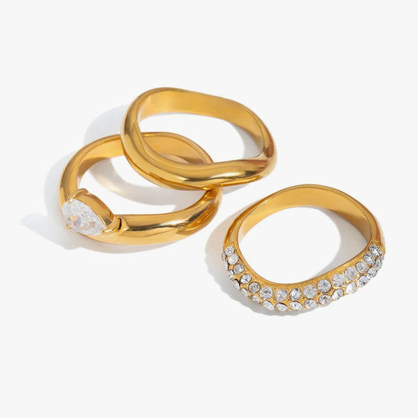 Three wave-form rings, one crystal-set and one with a pave band